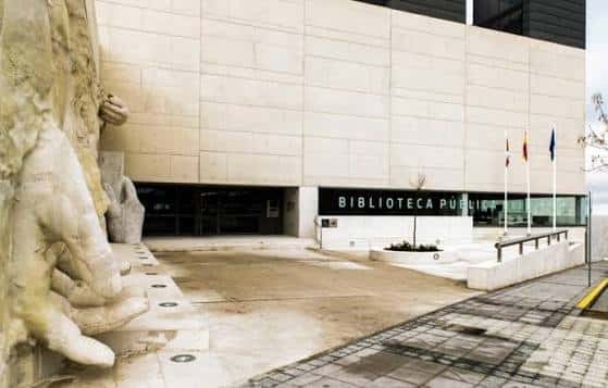 Entrada principal de la Biblioteca Pública con escultura y banderas