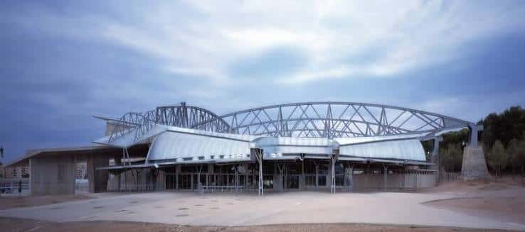 Vista panorámica del exterior del pabellón con estructura metálica y techo ondulado