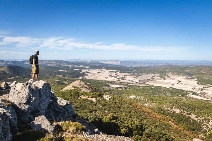Hiker contemplando el paisaje desde una roca en el Parque Natural de la Font Roja