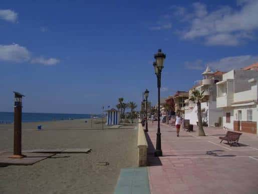 Vista panorámica del paseo marítimo con farolas y edificios blancos frente al mar
