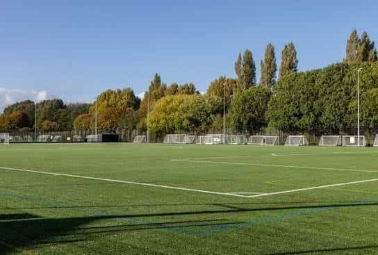 Vista panorámica de los campos de fútbol King George V con césped artificial y porterías bajo un cielo despejado