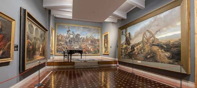 Galería del museo con piano y obras de arte enmarcadas