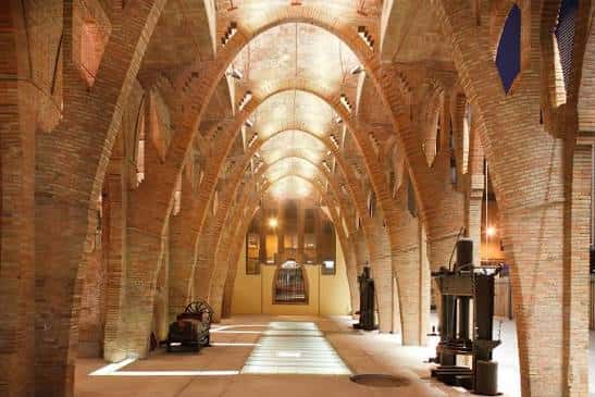 Vista interior del Celler Modernista con bóvedas de ladrillo y maquinaria histórica