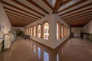 Galería principal del centro con techos de vigas de madera y arcos de ladrillo