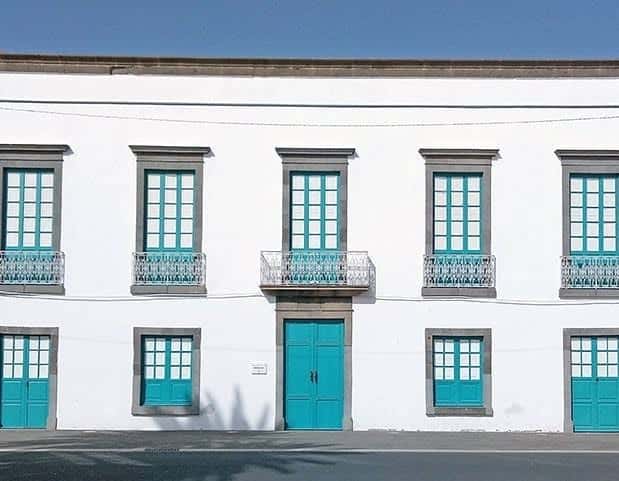 Fachada principal de la Casa de la Cultura Agustín de la Hoz con ventanas y balcones de color turquesa