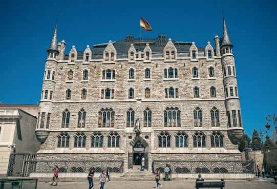 Fachada principal de la Casa Botines con bandera española
