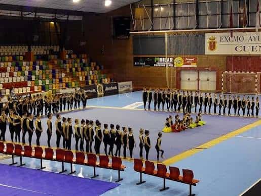 Evento deportivo en el pabellón con equipo de gimnasia en formación sobre la pista