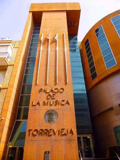 Fachada principal del Palacio de la Música en Torrevieja con detalles arquitectónicos y banderas