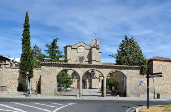 Fachada principal del Real Monasterio de Santo Tomás con arco de entrada y jardines