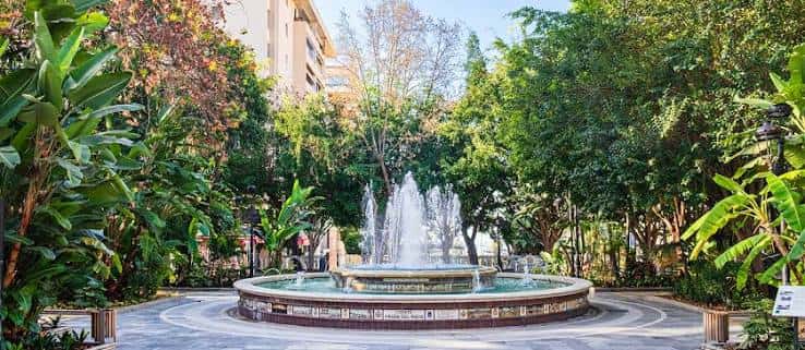 Fuente central del Parque de la Alameda rodeada de vegetación tropical
