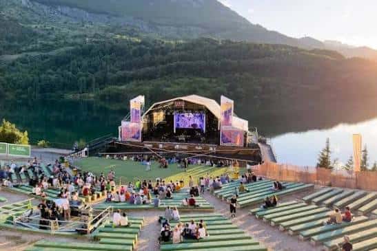 Concierto en el Auditorio Natural de Lanuza con público sentado en las gradas y escenario iluminado