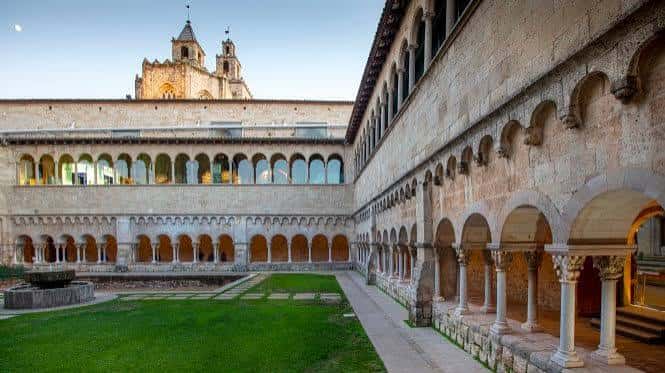 Claustro románico del monasterio con arcos, columnas y jardín central