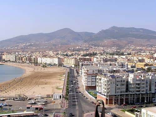 Panorama aéreo de la Playa de San Lorenzo con la ciudad y montañas al fondo