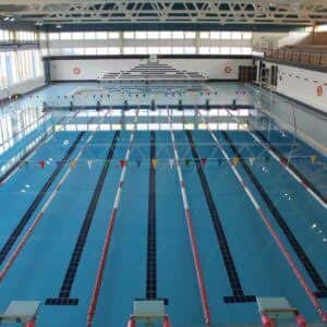 Piscina cubierta con carriles de natación y gradas en el fondo