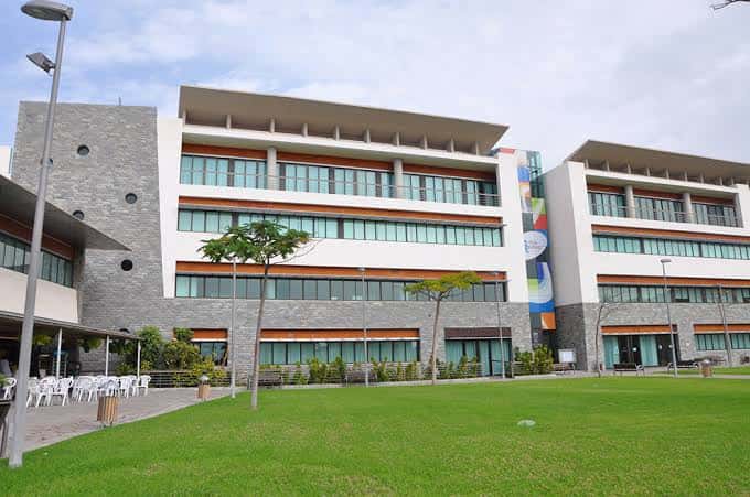 Exterior del edificio con zona de eventos al aire libre y sillas blancas dispuestas