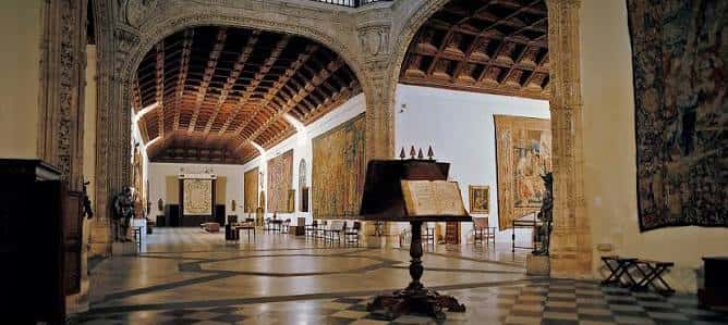 Salón principal del museo con techos de madera y tapices históricos