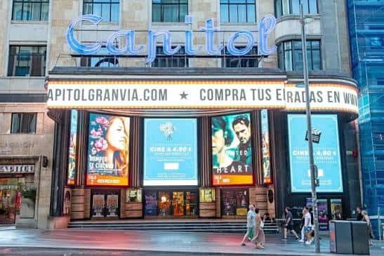 Fachada diurna del Teatro Capitol Gran Vía con cartelera de cine y letrero luminoso