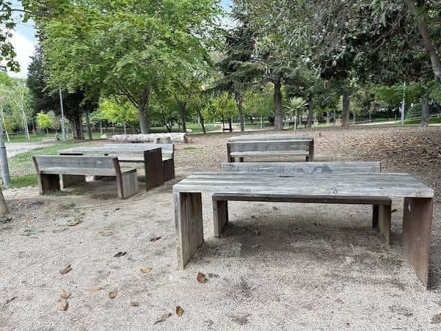 Zona de picnic con mesas y bancos de madera en el parque