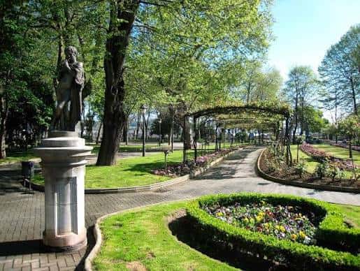 Vista panorámica del Parque del Muelle con senderos, jardines y una estatua en primer plano