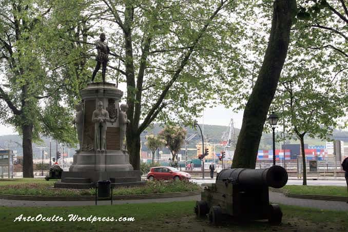 Monumento histórico con cañón en el Parque del Muelle, con vista al puerto al fondo