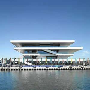 Fachada exterior moderna del Auditorio Marina Sur frente al puerto en día soleado