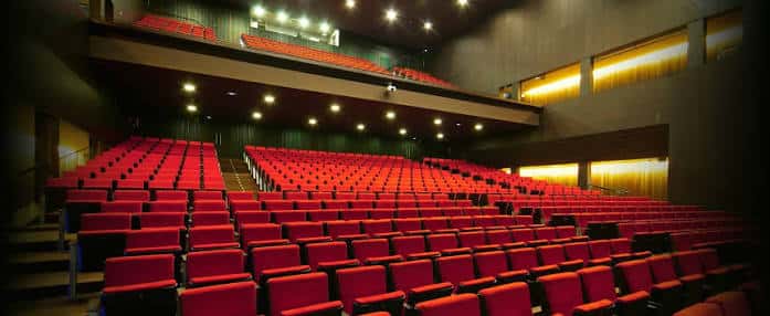 Interior de la Sala Gran con butacas rojas y escenario