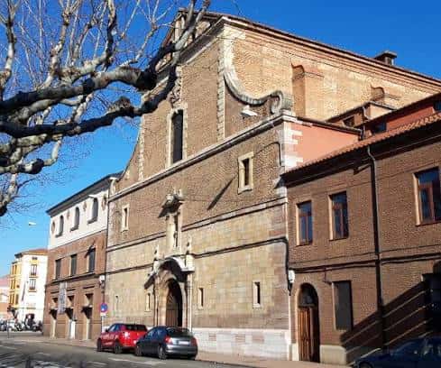 Fachada exterior del Convento de San Francisco de Asís en León, con arquitectura de ladrillo y piedra bajo un cielo azul