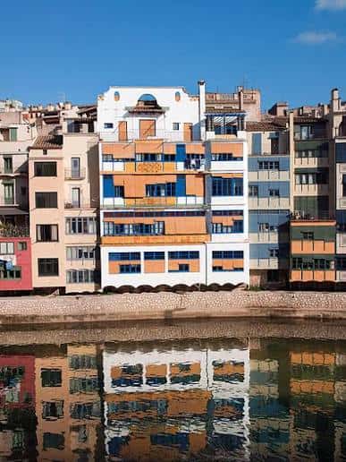 Vista panorámica de Casa Masó junto al río Onyar con su reflejo en el agua