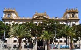 Vista exterior del Palacio Provincial de Alicante con fachada neoclásica y palmeras