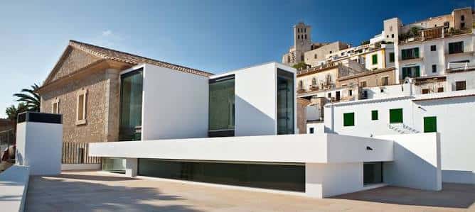 Vista panorámica del edificio MACE integrando arquitectura moderna y tradicional con torre al fondo