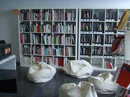 Interior de la biblioteca con estanterías de libros y sillones tipo beanbag para lectura