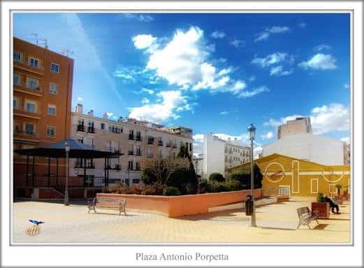 Vista panorámica de la Plaza Antonio Porpetta con edificios residenciales y cielo azul