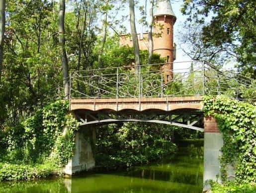 Vista del puente con la torre del castillo al fondo entre árboles