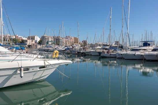 Vista del puerto deportivo con yates amarrados y reflejos en el agua