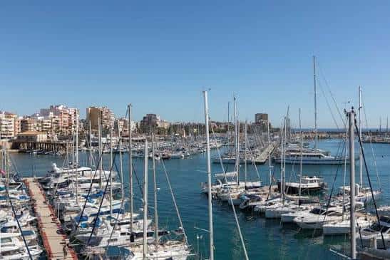 Panorámica del Club Náutico Marina Internacional con múltiples veleros y ciudad al fondo