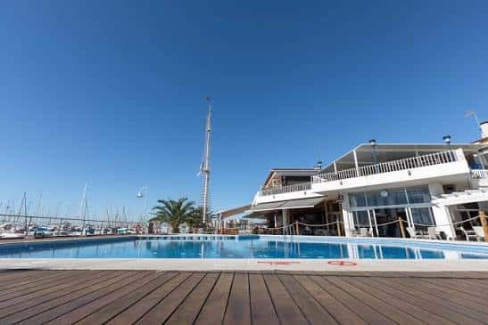 Vista del club náutico con piscina y muelle de embarcaciones al fondo