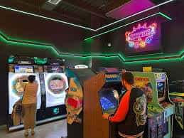 Interior del museo con máquinas arcade retro y luces de neón