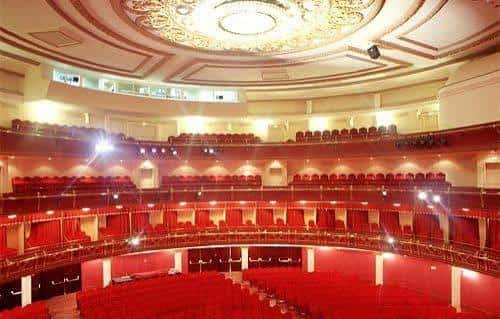 Salón principal del teatro con balcones curvos y techo decorado