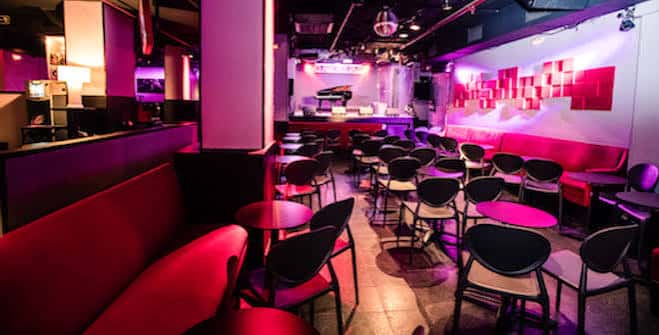 Interior de la sala Clamores con mesas, sillas y decoración moderna