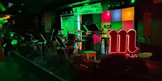 Escenario del club con instrumentos musicales y luces de colores