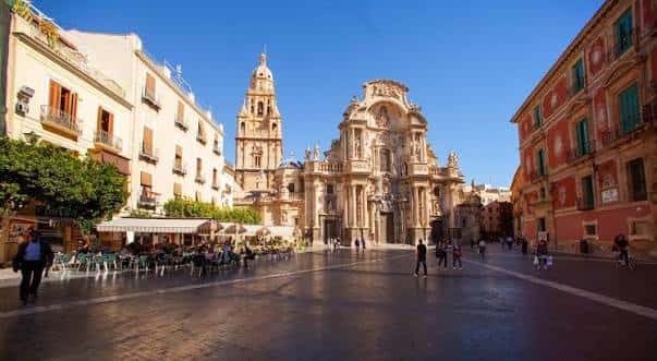 Vista diurna de la Plaza del Cardenal Belluga con la Catedral de Murcia al fondo y terrazas de cafetería
