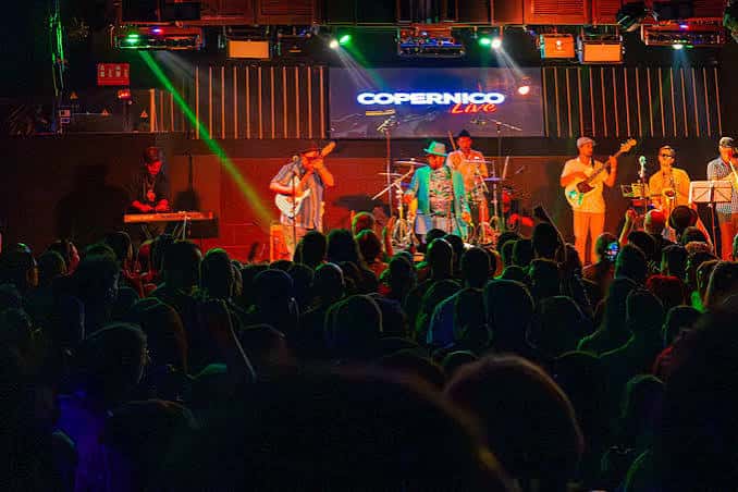 Concierto en vivo en el escenario de la sala Copérnico con banda y público