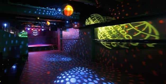 Pista de baile con luces de discoteca y escenario