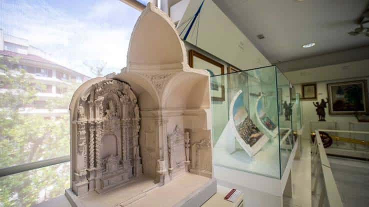 Detalle de una réplica arquitectónica en piedra y vitrinas de exhibición en el interior del museo