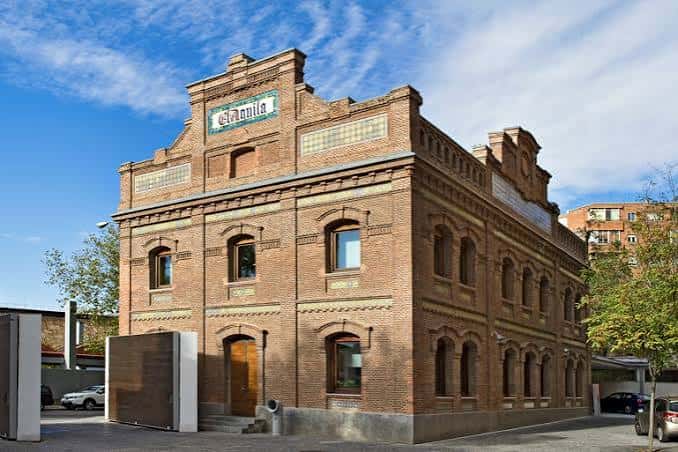 Vista exterior del edificio histórico de ladrillo con el letrero de El Águila