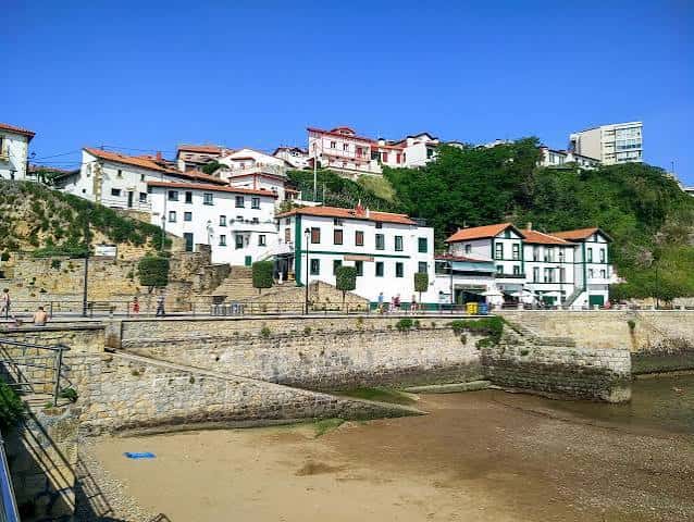 Vista panorámica del Puerto Viejo de Algorta con casas blancas y tejados rojos en una colina verde
