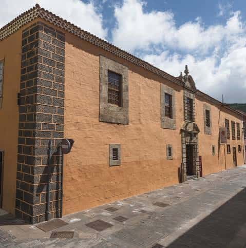 Fachada exterior del Museo de Historia y Antropología de Tenerife (Casa Lercaro) con muros amarillos y detalles en piedra volcánica