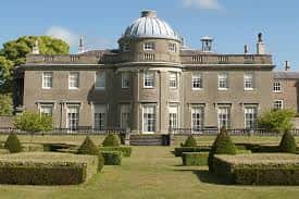 Fachada principal de Scampston Hall con cúpula y jardines frontales