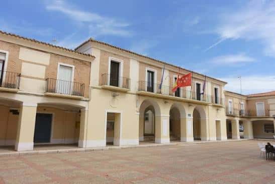 Plaza Mayor del Real Cortijo de San Isidro con fachada de arcos y banderas