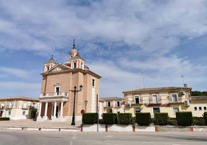 Iglesia del Real Cortijo de San Isidro con fachada de ladrillo y columnas blancas